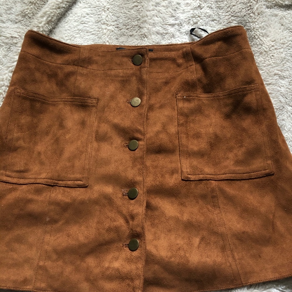 A  tan mini skirt with a suede detailing